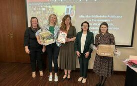 Pięć kobiet stoi obok siebie i uśmiecha się, dwie z nich trzymają nagrody opakowane folią, w tle napis Najlepsi z Najlepszych DKK w 2023 r. 