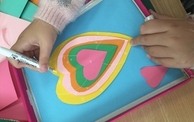 Praca plastyczna i dłonie dziecka trzymające marker.