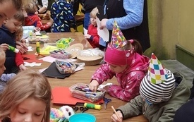 Kobieta mówi do siedzących obok dzieci.