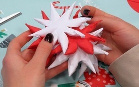 Dłonie trzymające ozdobę świąteczną z papieru.