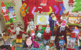 Dzieci w otoczeniu dekoracji świątecznych. Trzymające w ręky swoje prace plastyczne. 