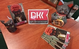 Logo DKK, figurki kota maneki neko i książki Katarzyny Ryrych.
