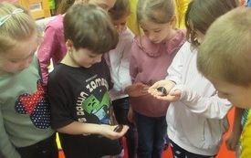 Dzieci trzymają w ręku duże owady. 