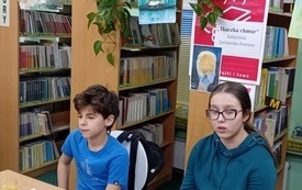 Chłopiec z dziewczyną siedzą przy stoliku i patrzą się przed siebie.