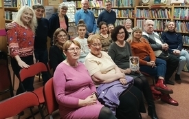 Uczestnicy spotkania pozują do wspólnej fotografii z gościem spotkania.