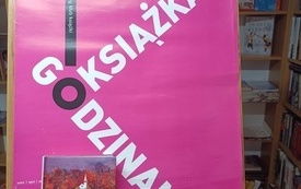 Na tablicy książka, logo DKK. 