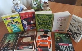 Na stole książki, za nimi dekoracja wielkanocna.