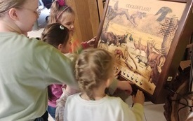 Dziewczynki stojące przy obrazie ze zwierzętami lasu, z możliwością odsłuchania odgłosów.