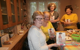 Kilka kobiet pozuje do wsp&oacute;lnego zdjęcia, jedne siedzą drugie stoją w ręce mają książki. 