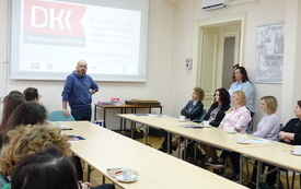 Robert Maciąg, edukator stoi i m&oacute;wi do bibliotekarzy. 