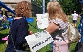 Dwie kobiety trzymają w ręku gazetę jednodni&oacute;wkę.