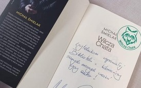 Na stoliku książka z autografem. 