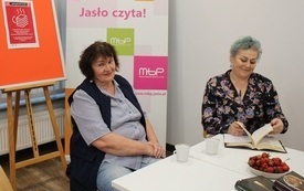 Dwie kobiety siedzą przy stole i dyskutują 