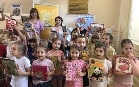 Grupa dzieci pozuje do zdjęcia trzymając książki
