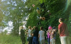 Dzieci w parku rzucają w g&oacute;rę czapki i kapelusze