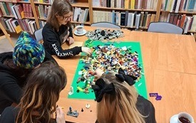 Młodzież układa klocki LEGO.