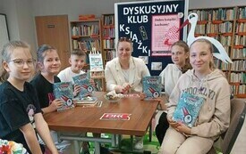 Kilka osób dyskutuje przy stole.