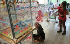Dzieci podczas malowania morskich stworzeń na folii.