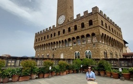 Młoda kobieta pozuje do zdjęcia przed budynkiem Palazzo Vecchio