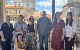 Grupa uczestników kursu pozuje do zdjęcia na tarasie, w tle widoczna katedra we Florencji