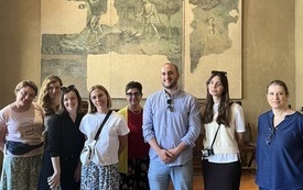 Grupa uczestników kursu pozuje do zdjęcia w muzealnej sali