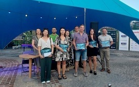 Grupa osób z dyplomami na pamiątkowym zdjęicu.