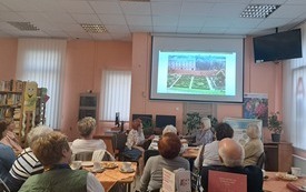 Prowadząca wykład wskazuje na prezentacji fotografię gorodu.