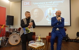 Artur Barciś i Zbigniew Pacho stoją i rozmawiają. W tle ekran multimedialny.