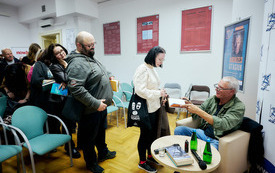 Dziewczyna odbiera książkę z autografem od autora. Za nią kolejka czytelnik&oacute;w.