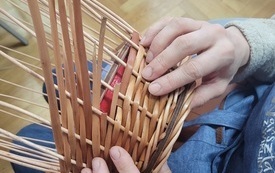 Dłonie tworzące koszyk wiklinowy.