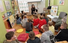 Bibliotekarka i dzieci podczas zajęć bibliotecznych. 