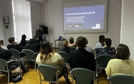 Na ścianie prezentacja, męzczyzna opowiada coś uczestnikom.