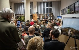 Wnętrze biblioteki wypełnione ludźmi.