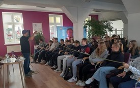 Autor, Robert Maciąg stoi przed grupą młodzieży