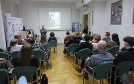 Publiczność siedząca w bibliotecznej sali