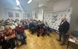 Mężczyzna w średnim wieku stoi przed publicznością