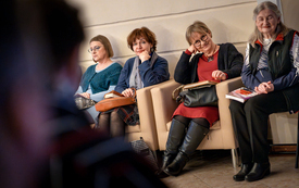 Kobiety siedzące na fotelach z książkami na kolanach. 