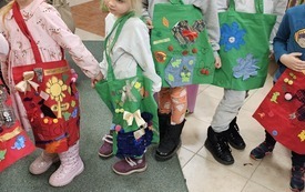Dzieci pozują do zdjęcia z własnoręcznie ozdobionymi torbami na zakupy