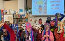 Grupa dzieci pozuje do zdjęcia w karnawałowych maskach
