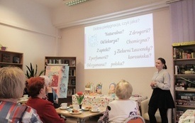 Bibliotekarka prowadzi spotkanie dla seniorek.