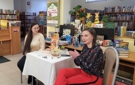 Dwie młode kobiety podczas rozmowy o książce.