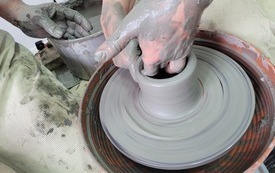 Proces tworzenia naczynia na kole garncarskim.