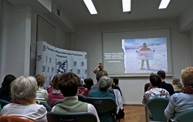 W sali audiowizualnje trwa spotkanie autorskie z podróźnikiem.