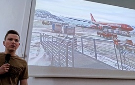 Mężczyzna z fotografią samolotu w tle.