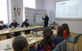 Widok sali szkoleniowej i prowadzącego piszącego na tablicy