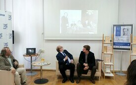 Trzech mężczyzn rozmawiających na kanapie.