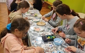 Przy stolikach młodzież wykonuje kartki metodą scrapbookingową