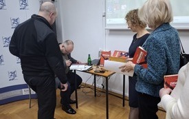 Czytelnicy stoją w kolejce po autografy prelegenta
