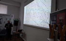 Prelegent prezentujący slajdy na ekranie