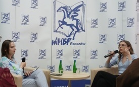 Dwie młode kobiety rozmawiają siedząc na fotelach naprzeciw siebie